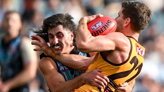 Luke Breust of the Hawks is tackled by Lachie Jones.