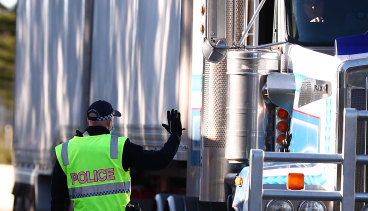 Queensland police stop trucks at the Queensland border.