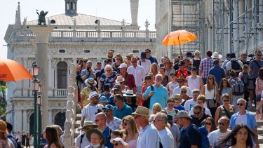 Tourists on the Ponte della Paglia historic footbridge in Venice in June.