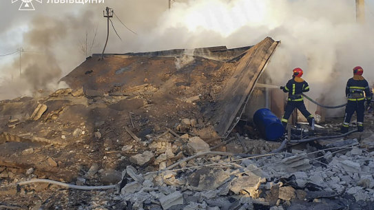 In this photo provided by the Ukrainian Emergency Service, emergency services workers extinguish a fire following a Russian rocket attack in Lviv, Ukraine, on Sunday, November 17.