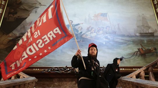 WASHINGTON, DC - JANUARY 06: A protester holds a Trump flag inside the US Capitol Building near the Senate Chamber on January 06, 2021 in Washington, DC. Congress held a joint session today to ratify President-elect Joe Biden's 306-232 Electoral College win over President Donald Trump. A group of Republican senators said they would reject the Electoral College votes of several states unless Congress appointed a commission to audit the election results. (Photo by Win McNamee/Getty Images) .