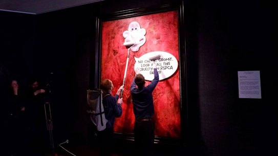 Activists paste a picture of  Wallace over the portrait of King Charles III at the Philip Mould Gallery in London. 