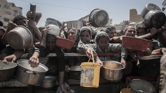Palestinians gather to receive food from a charity distribution point in the city of Gaza.