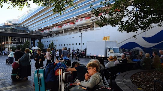 Passengers sit with their luggage after disembarking from the Ruby Princess cruise ship on March 19 at Circular Quay, Sydney.