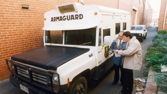 Police examine the abandoned Armaguard van after the 1994 armed robbery in Richmond.