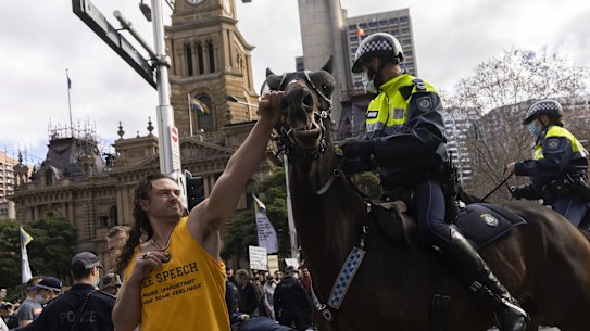 A man punches a Police Horse during an anti-lockdown rally in the CBD in Sydney 24 July, 2021. Photo: Brook Mitchell