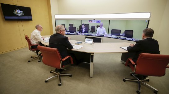 Secretary of the Prime Minister’s Department, Phil Gaetjens, Prime Minister Scott Morrison and then-Chief Medical Officer Professor Brendan Murphy, speak with NSW Premier Gladys Berejiklian (on screen) during a National Cabinet meeting.