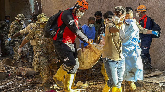 Rescuers retrieve the body of a flooding victim in Derna.