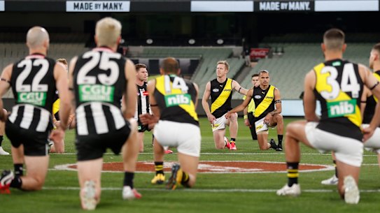 Collingwood and Richmond players take a knee on Thursday night.