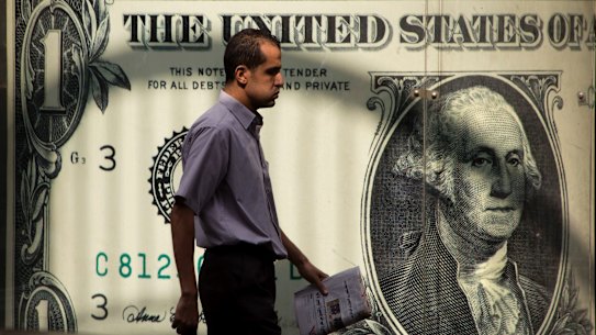 A man walking past a currency exchange office in Cairo. The greenback’s status as the world’s reserve currency is in danger as the the world's largest economy is in turmoil.