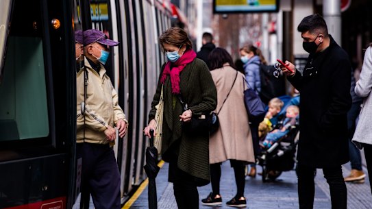 People wearing masks in Sydney’s CBD. From Wednesday, people in NSW, Queensland and South Australia won’t have to wear masks on public transport. 