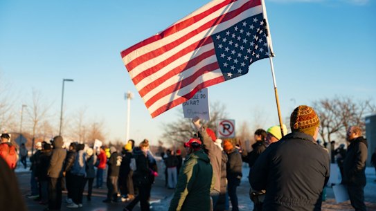 Demonstrators in St. Paul, Minnesota, carry an upside-down US flag in protest at a killing by an ICE agent.