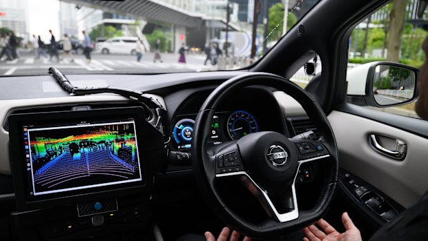 A driver takes their hands off the wheel of a Nissan Leaf electric vehicle equipped with autonomous driving technology during a test ride in the Yokohama, Japan.