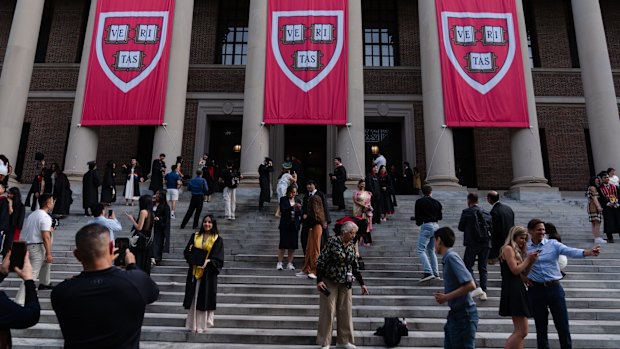 Students take photos on the steps of the Harry Elkins Widener Memorial Library at Harvard University.