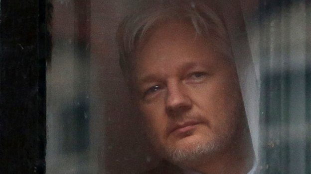 Julian Assange looks out a window of the Ecuadorian embassy in London, where he stayed for nearly seven years.