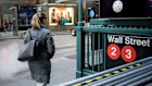 A pedestrian on Wall Street in New York. Results from major American corporations will set the tone for the market, and drive local shares this week.