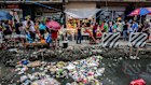 Trash lies in a gutter as customers shop at Quiapo Market in Manila, the Philippines, in 2017.