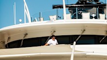 A crew member cleans an upper railing on the yacht Casino Royale at the International Boat Show in Fort Lauderdale.