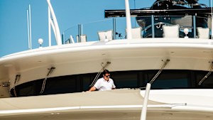 A crew member cleans an upper railing on the yacht Casino Royale at the International Boat Show in Fort Lauderdale.
