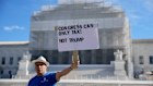 A demonstrator outside the US Supreme Court, where the tariff case is being heard.