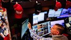 A trader works below Trump hats on the floor of the New York Stock Exchange. Wall Street fell on fears of a renewed trade war with China.