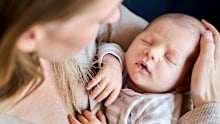 Close-up of caring mother lovingly holding her newborn baby in a close embrace (stock image)