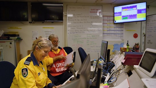 NSW RFS volunteers Air Ops Manager Peter Windle (right) and Aviation Radio Operator Danielle Brice (left) working in the Operations room at the Eurobodalla Operations Fire Control Centre, Moruya. NSW. 3rd January, 2020. Photo: Kate Geraghty

