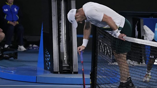 Andy Murray of Britain rests on the net during his third round match against Roberto Bautista Agut of Spain.