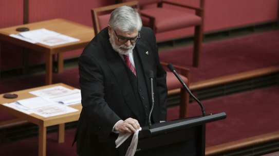Senator Kim Carr wipes down the lectern before speaking during debate in the Senate in 2020.