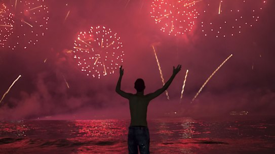 A man watches fireworks exploding over Copacabana Beach during the New Year's celebrations, in Rio de Janeiro, Brazil, Wednesday, Jan. 1, 2020. (AP Photo/Bruna Prado)
