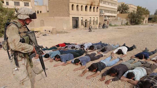 A Marine arrests suspected looters along the Tigris river in Baghdad, Sunday April 13, 2003. 