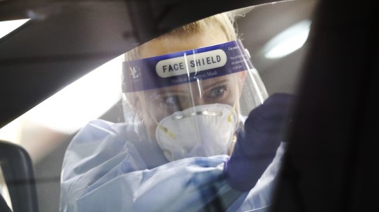 MELBOURNE, AUSTRALIA - MAY 05: A medical practitioner performs a test on a member of the public at a drive through testing clinic in the carpark of Bunnings in West Footscray on May 05, 2020 in Melbourne, Australia. The Victorian Government has set up additional COVID-19 testing clinics across Melbourne in a bid to test up to 100,000 people in two weeks. Victorians with even the mildest symptoms are being asked to go get tested, as the state pushes to stop the further spread of coronavirus (COVID-19). Tough restrictions on movement and gatherings remain in place across Victoria despite a decline in the number of confirmed coronavirus cases across Australia. All non-essential businesses remain closed or are restricted in operation, while public gatherings are limited to two people and social distancing measures require people to keep a safe 1.5m distance from one another. All international arrivals into Australia are being sent to mandatory quarantine in hotels for 14 days. (Photo by Darrian Traynor/Getty Images)