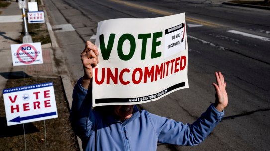 A volunteer holds a sign outside a polling station at Oakman School in Dearborn, Michigan.