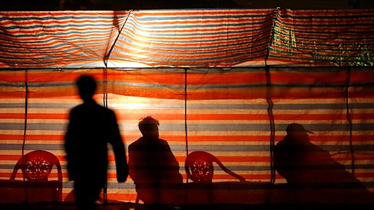 Customers wait for their meal at a self-powered street stall in an electricity-restricted area in Changsha, Hunan Province.