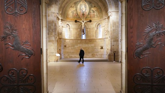 Visitors and staff wearing protective masks observe COVID-19 prevention protocols in halls of The Met Cloisters, a branch of the Metropolitan Museum of Art dedicated to medieval European art in New York.