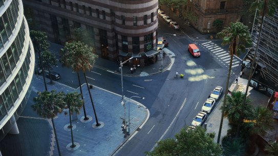 An aerial view of a man pushing a trolley across a near empty Bent street in the CBD of Sydney. Scope economists argue that after the virus restrictions pass, governments will have to look at stimulus to re-boot the economy.