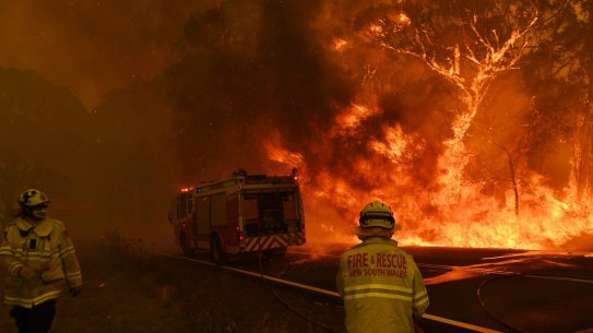 Fire and Rescue NSW escape flames as the Gospers mtn fire crosses the Bells Line of Rd at Berambing. 19 December 2019. Photo Nick Moir.
