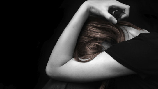 Stressed woman with her head in her arm.