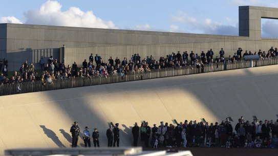 People watching the 96 gun salute to mark the death of Her Majesty the Queen, Elizabeth II, at the Parliament House forecourt, in Canberra on Friday, September 9. 