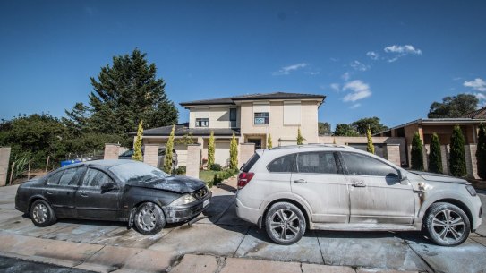 Police officers and froensic staff attend the scene of an overnight shooting and arson attack in Harrington circuit, Kambah. Three bullets have hit the home and two vehicles have been set alight. 