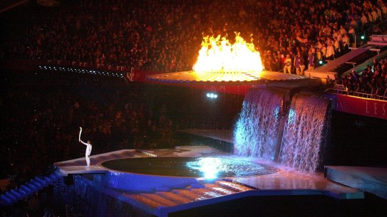 Cathy Freeman holds up the Olympic torch at the end of the opening ceremony of the 2000 Olympics in Sydney.  (AP Photo/Laura Rauch)