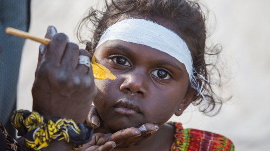 A Gumatj girl being painted in traditional colours for bunngul (ceremonial dances) at Garma in north-east Arnhem Land. 