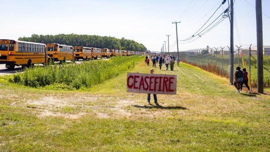 A demonstrator holds a sign calling for a pause in hostilities in the Middle East ahead of a campaign event with Democrat nominee Kamala Harris in Detroit, Michigan.