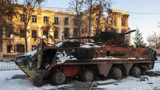 A destroyed armored personnel carrier stands in front of a damaged by shelling building in Kharkiv, Ukraine, Friday, March 11, 2022. (AP Photo/Andrew Marienko)