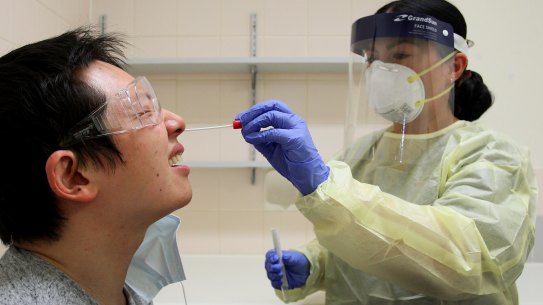 SYDNEY, AUSTRALIA - MAY 15: Registered Nurse Sharan Coulter conducts a nasal swab test on Shi Yang Liu in the clinical assessment room at St George Hospital COVID-19/ Flu Assessment Clinic on May 15, 2020 in Sydney, Australia. St George Hospital has been operating a COVID-19 and flu assessment clinic since 19 March 2020. Since being set up in response to the global coronavirus pandemic, approximately 4107 patients have visited the clinic (as of 13 May 2020), an average of 513 patients per week or 75 per day. The COVID-19 clinic operates seven days a week and is staffed by a team of doctors, nurses, admin support workers, wardspersons and cleaners. All patients are provided with education regarding COVID-19 symptoms, home isolation requirements, hand and respiratory hygiene. If they meet testing criteria, a nose and throat swab is collected. Patients who have been tested are given masks to take home and further information on how to register for AutoSMS or NSW Service App to retrieve their results. While testing in Australia was initially restricted to people who had been in contact with a confirmed COVID-19 case or had severe symptoms, as the country's confirmed infection rate continues to decline and restrictions on social distancing and gatherings begin to ease around the country, Australians with even the mildest symptoms are now being urged to get tested to avoid any coronavirus infection flare ups. In New South Wales nearly 346,000 people have been tested for COVID-19 (as of 14 May 2020), which is one of the highest testing rates in the world. (Photo by Lisa Maree Williams/Getty Images)