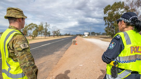 Australian Army soldier Lance Corporal Jacob Binns (left) from the 6th Battalion, Royal Australian Regiment, and Senior Constable Megan Down from the Queensland Police Service at a police control point near Hebel on the Queensland/NSW border during Operation COVID-19 Assist.