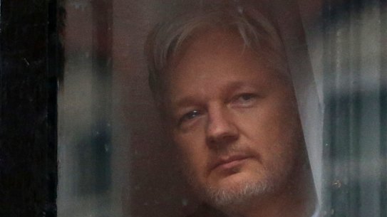 Julian Assange looks out a window of the Ecuadorian embassy in London, where he stayed for nearly seven years.
