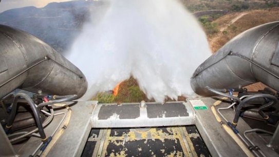 In this photo released by Brazil Ministry of Defense, a C-130 Hercules aircraft dumps water to fight fires raging in Brazil's Amazon, on Saturday.