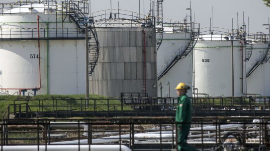 An employee walks past oil storage tanks in the Duna oil refinery, operated by MOL Hungarian Oil & Gas Plc, in Szazhalombatta, Hungary, on Monday, April 10, 2017. MOL Group posted almost $1 Billion profit in 2016. Photographer: Oliver Bunic/Bloomberg