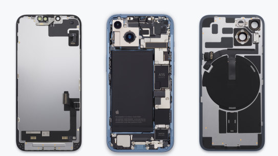 The internal design of the iPhone 14, which can be opened from either side, with most components accessible from the back. If you’re imagining putting the phone back together from this image, the display (on the left) would go under the central structure, with the back glass (right) flipping over and going on top.
